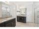 Modern bathroom featuring dual vanities, granite countertops, and a glass-enclosed shower at 10625 Cardera Dr, Riverview, FL 33578