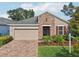 Inviting single-Gathering house with a brick driveway, attached two-car garage, and professionally landscaped front yard at 10625 Cardera Dr, Riverview, FL 33578