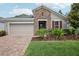 Charming single-story home with a brick facade, well-manicured lawn, and two-car garage at 10625 Cardera Dr, Riverview, FL 33578