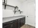 Granite countertops and cabinetry accent the mudroom's design, complemented by wood-look flooring at 10625 Cardera Dr, Riverview, FL 33578