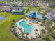 Aerial image of community pool with crystal-clear water, surrounding lounge chairs, and palm trees for the perfect relaxation at 10625 Cardera Dr, Riverview, FL 33578