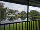 A balcony view featuring a tranquil pond, community pool, and verdant landscaping at 11201 122Nd Ave # 126, Largo, FL 33778