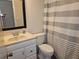 A modest bathroom with a white sink cabinet, functional toilet, and a shower curtain, ensuring essential amenities at 11201 122Nd Ave # 126, Largo, FL 33778