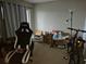 Bedroom space with a desk, gaming chair and a bike, filled with boxes and assorted clutter at 11201 122Nd Ave # 126, Largo, FL 33778