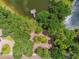 Aerial shot of a dock leading into a pond, nestled among trees, with a brick driveway at 11624 Calf Path Dr, Tampa, FL 33626