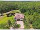 Expansive aerial view of a two-story home with a serene pond, surrounded by lush greenery and a large driveway at 11624 Calf Path Dr, Tampa, FL 33626