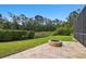 Backyard patio featuring a stone fire pit and a scenic view of the pond and greenery at 11624 Calf Path Dr, Tampa, FL 33626