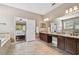 Large bathroom with tile floors, dual sinks, granite counters, tub and walk-in shower at 11624 Calf Path Dr, Tampa, FL 33626