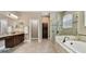 Spacious bathroom features dual vanity sinks, separate tub and glass enclosed shower and tile floors at 11624 Calf Path Dr, Tampa, FL 33626