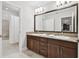 Bathroom with dual sinks, granite countertops, dark wood cabinets, and a shower tub combo at 11624 Calf Path Dr, Tampa, FL 33626