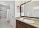 Bathroom features granite countertop, dark wood cabinets, large mirror, tile floor and shower at 11624 Calf Path Dr, Tampa, FL 33626