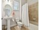 Bathroom features a pedestal sink, toilet, tub and shower combination with light colored tile at 11624 Calf Path Dr, Tampa, FL 33626