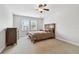 Cozy bedroom with ceiling fan, plush carpeting, and two windows with natural light at 11624 Calf Path Dr, Tampa, FL 33626