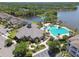 Aerial view of a community clubhouse with a swimming pool and well-maintained landscaping, near a beautiful lake at 11624 Calf Path Dr, Tampa, FL 33626