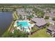 Expansive community pool area with lounge chairs, surrounded by lush landscaping and views of a serene lake at 11624 Calf Path Dr, Tampa, FL 33626