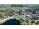An aerial view that showcases the home's location and the surrounding neighborhood with mature trees and a community pond at 12913 126Th Ter, Largo, FL 33774