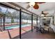Screened-in patio featuring a pool, a brick floor, and multiple ceiling fans at 12913 126Th Ter, Largo, FL 33774