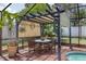 Outdoor patio with a dining table and chairs, overlooking the pool area at 12913 126Th Ter, Largo, FL 33774