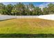 Spacious backyard showcasing a large green lawn enclosed by a white fence at 13174 Royal Pines Ave, Riverview, FL 33579