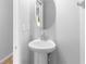 A pedestal sink and oval mirror complement this half bathroom at 13174 Royal Pines Ave, Riverview, FL 33579