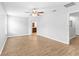 Spacious bedroom with wood-look flooring, ceiling fan, and adjoining bathroom at 13174 Royal Pines Ave, Riverview, FL 33579