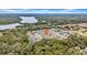Aerial view of a residential neighborhood surrounded by lush greenery and a lake, highlighting the community's landscape at 13855 Sharp Hawk Dr, Riverview, FL 33569
