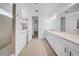 Bright bathroom with dual sinks, white cabinets, quartz counters, and tiled walk-in shower at 13855 Sharp Hawk Dr, Riverview, FL 33569