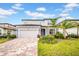 Charming two-story home featuring a paved driveway, lush landscaping, and an attached two-car garage at 13855 Sharp Hawk Dr, Riverview, FL 33569