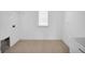 Tiled laundry room with washer hookups, bright lighting, and a window, providing functionality and convenience at 13855 Sharp Hawk Dr, Riverview, FL 33569
