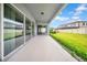 Covered patio with sliding glass doors that overlooks the green backyard; perfect for outdoor relaxation and entertainment at 13855 Sharp Hawk Dr, Riverview, FL 33569