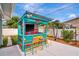 A vibrant outdoor bar with a colorful design, seating, and shade offers a unique entertainment space at 1398 Lemon St, Clearwater, FL 33756