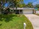 Charming one-story home with a well-manicured lawn, attached garage, and inviting curb appeal at 1398 Lemon St, Clearwater, FL 33756