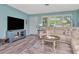 Comfortable living room with modern furnishings, a neutral sofa, and an entertainment center at 1398 Lemon St, Clearwater, FL 33756