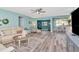 Open-concept living room with wood-look floors, flowing into the dining area and a cozy den at 1398 Lemon St, Clearwater, FL 33756