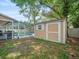 Backyard featuring a shed next to a screened-in pool area, surrounded by lush greenery at 16015 Glen Haven Dr, Tampa, FL 33618