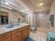Well-lit bathroom with a single vanity, a large mirror, and a shower-tub combination at 16015 Glen Haven Dr, Tampa, FL 33618