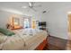 Bright bedroom featuring hardwood floors, a ceiling fan, and a large window with colorful curtains at 16015 Glen Haven Dr, Tampa, FL 33618
