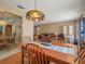 Inviting dining room with an ornate pendant light and hardwood floors, seamlessly flowing into the living area at 16015 Glen Haven Dr, Tampa, FL 33618