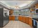 Well-lit kitchen with stainless steel appliances, wooden cabinetry, and a view of the backyard at 16015 Glen Haven Dr, Tampa, FL 33618
