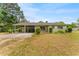 Charming single-story home featuring a carport, green landscaping, and a well-maintained lawn at 1609 S Valrico Rd, Valrico, FL 33594