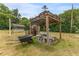 Outdoor wooden gazebo and BBQ area with a wheelbarrow in a private backyard at 1609 S Valrico Rd, Valrico, FL 33594