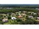 An aerial view of single-Gathering homes and lush green trees in a quiet neighborhood surrounding a placid lake at 16124 Suncrest Shores Dr, Odessa, FL 33556