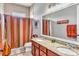 Bathroom featuring double sinks, granite countertop, and decorative shower curtain at 16124 Suncrest Shores Dr, Odessa, FL 33556