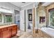 An elegant bathroom featuring a soaking tub, granite counters, and tiled flooring. Neutral colors create a spa experience at 16124 Suncrest Shores Dr, Odessa, FL 33556