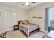 Bedroom featuring neutral decor, carpeted floors, and a window allowing ample natural light. Functional closet and shelves at 16124 Suncrest Shores Dr, Odessa, FL 33556