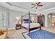 A bedroom with a four-poster bed, blue accents, and a ceiling fan for added comfort and style at 16124 Suncrest Shores Dr, Odessa, FL 33556