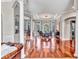 Elegant dining room with wood floors, tray ceiling, chandelier, and large windows overlooking the grounds at 16124 Suncrest Shores Dr, Odessa, FL 33556