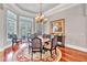 Comfortable dining area illuminated by a hanging chandelier with chairs, table, and an area rug at 16124 Suncrest Shores Dr, Odessa, FL 33556