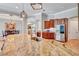 Open kitchen with a large island, stainless steel refrigerator, and views into the formal dining area at 16124 Suncrest Shores Dr, Odessa, FL 33556