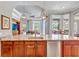 Open concept kitchen island has granite countertop, wood cabinets, and stainless steel dishwasher at 16124 Suncrest Shores Dr, Odessa, FL 33556